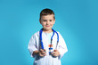 © New Africa - Cute child in doctor coat with stethoscope on color background