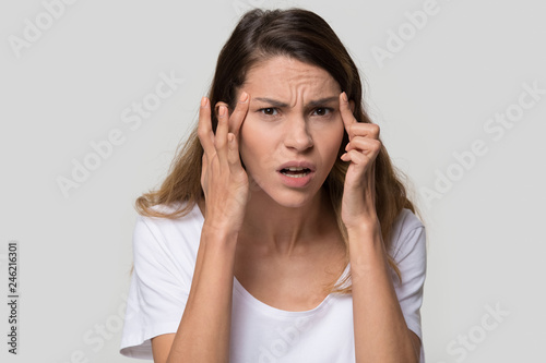 Stressed young woman confused about facial wrinkles aging skin on forehead or cr Obraz na płótnie
