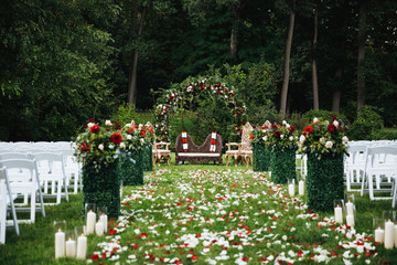 Wall Mural - Rose petals cover green garden ready for traditional Hindu wedding ceremony