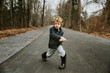 © Cavan Images - Portrait of boy playing with stick on road