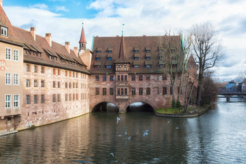 Wall Mural - Heilig-Geist-Spital (Hospice of the Holy Spirit) in Old Town Nuremberg, Germany. View from the Museum Bridge on the River Pegnitz