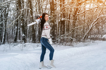 Poster - Woman in a sweater and jeans holds a chainsaw on his shoulder, goes in a snowy forest. Job search, sawing wood, employment, deforestation.