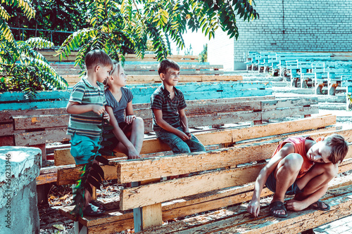 Orphaned Children Sit In An Abandoned Park On Old Benches Buy