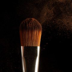 Poster - Close up powder splash and brush for makeup artist or beauty blogger in black background