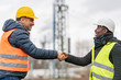 Successful handshake deal: multi-ethnic engineers reaching an agreement on construction site