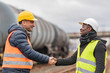 Successful handshake deal: multi-ethnic engineers reaching an agreement on construction site