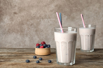 Glasses with healthy protein shake and berries on table. Space for text