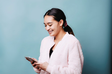 Young teen female laughs at her phone text smiling