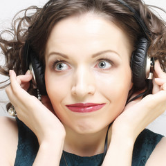 Wall Mural - Young happy woman with headphones listening music