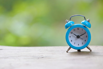 Retro pastel blue alarm clock in outdoor environment