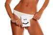 © vladimirfloyd - Woman with panties cowers her vagina with smile drawn on sheet of paper on white background