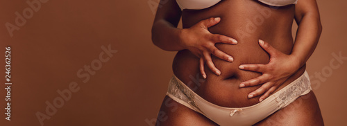 Fotomural African female holding her fat belly.