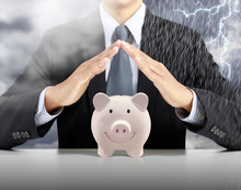 Businessman Hand Cover Pink Piggy Ceramic Bank With Heavy Rain Storm Background, Insurance