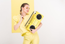 Beautiful Stylish Girl Holding Retro Boombox And Posing With Limelight On Background