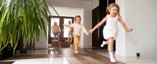 Horizontal Photo Happy Little Kids Running Into New Home, Parents With Cardboard Boxes On Background. Loan Mortgage, Moving Relocating Concept Banner For Website Header Design With Copy Space For Text