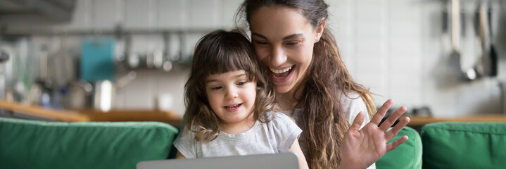 Mixed race mother and daughter using computer make video call waving hands greeting friend, having fun online modern tech applications concept banner for website header design with copy space for text