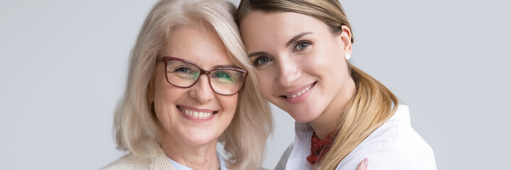 Close up attractive women faces smile look at camera, aged mother young daughter, different generations good warm relations concept horizontal banner for website header design with copy space for text