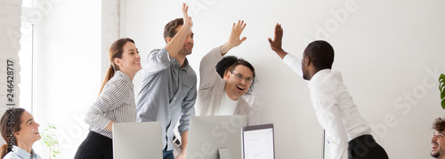 Canvas Print Happy diverse workmates giving high five celebrating corporate success feels exc