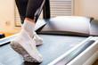 © Yakov - Close up female feet on modern treadmill in gym