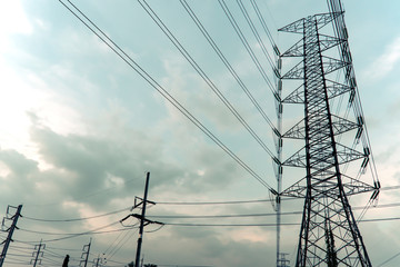 Electricity pole against blue sky clouds in dawn time, Transmission line of electricity to rural, High voltage electricity pole on bright sky clouds background, electricity transmission pylon