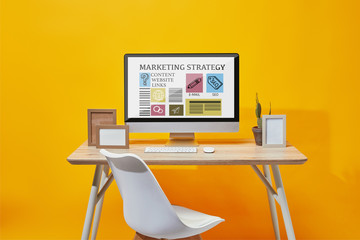 Sticker - Computer with marketing strategy website on screen at wooden table on yellow background