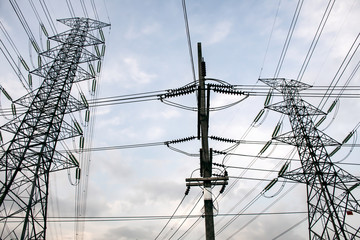 Electricity pole against blue sky clouds in dawn time, Transmission line of electricity to rural, High voltage electricity pole on bright sky clouds background, electricity transmission pylon