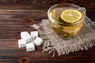 Wall Mural - Sugar and green tea with lemon on wooden background.