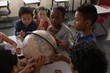 © wavebreak3 - Group of kids studying a globe together in classroom