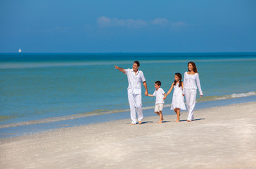 Mother, Father and Children Family Walking on Beach