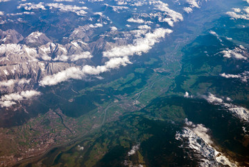 Wall Mural - Aerial view of Alps mountains with snow on mountain peaks seen from an airplane