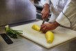 © Christopher - Chef slicing yellow squash on white cutting board