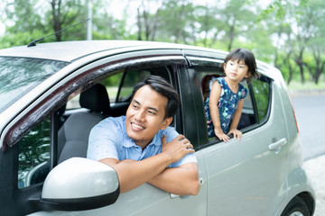 portrait father and his daughter looks out from a car windows