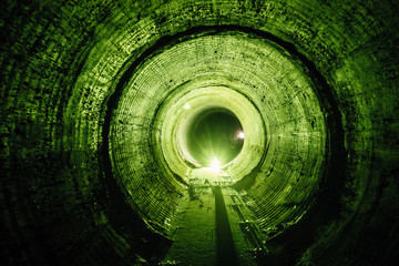 Wall Mural - Flooded round underground drainage sewer tunnel with dirty sewage water green illuminated