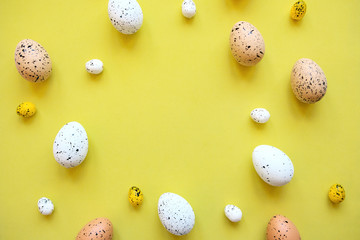 Wall Mural - Set of colored eggs on a yellow background. Festive Easter concept. In the middle there is a place for text.