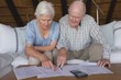 © WavebreakMediaMicro - Senior couple discussing over medical bills in living room