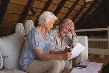 Wall Mural - Senior couple discussing over medical bills in living room