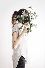 Woman Hiding Her Face With A Plant Bouquet