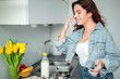 © Serhiy Hipskyy - Girl cooking pancakes in the kitchen, home with flowers, eggs, fruits on the table.