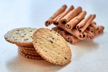 Fresh and tasty biscuits with cinnamon sticks on white background