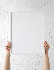 Holding frame mockup. Photo Mockup. Man hands hold frame. For frames and posters design. Frame size 16x20 (40x50cm).