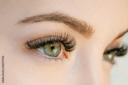 Fotomural Close up view of beautiful green female eye with long eyelashes, smooth healthy skin