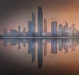 Fototapeta Miasta - Cityscape of Abu Dhabi Skyline at misty sunrise, UAE