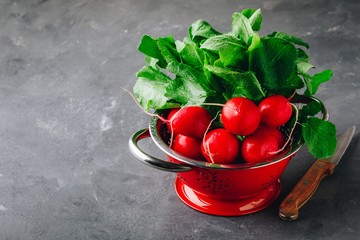 Wall Mural - Large bunch of raw fresh garden radish  in red colander