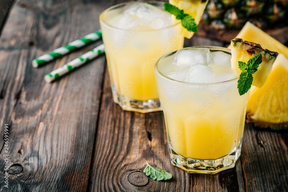 Photo & Art Print Fresh pineapple juice in two glasses with ice ...