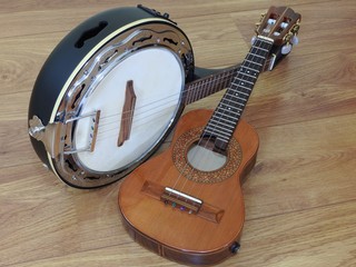 Two Brazilian string musical instruments: cavaquinho and samba banjo on a wooden surface. They are widely used to accompany samba, the most famous Brazilian rhythm.