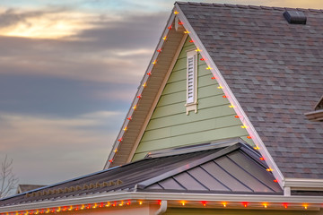 Roof with christmas lights against cloudy sky