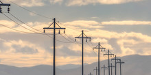 Row Of Electricity Posts Against Mountain And Sky
