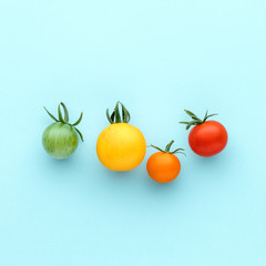 colorful organic cherry tomatoes on a blue background, creative flat lay healthy food concept, top v