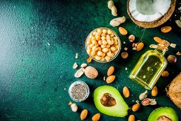 Wall Mural - Healthy vegan fat food sources, omega3, omega6 ingredients - almond, pecan, hazelnuts, walnuts, olive oil, chia seeds, avocado, coconut,  banner copy space