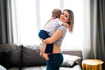 A mother with his child son on the living room close to the window